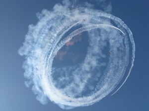 Jet planes circling in the cloud with a sky diver in the middle